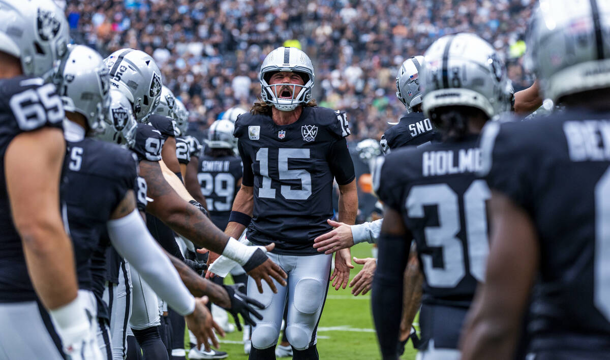 Raiders quarterback Gardner Minshew (15) yells as teammates greet him on the field before the f ...