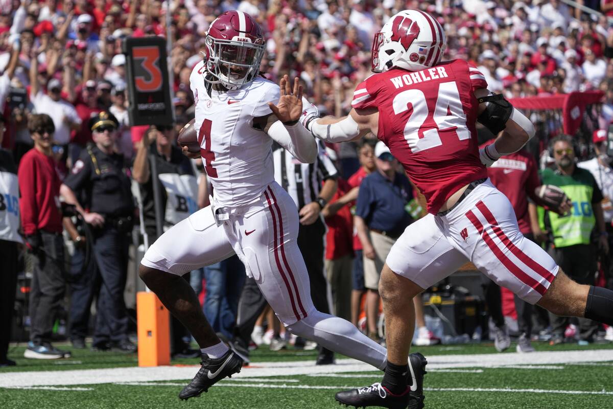 Alabama's Jalen Milroe (4) runs past Wisconsin's Hunter Wohler (24) for a touchdown during the ...