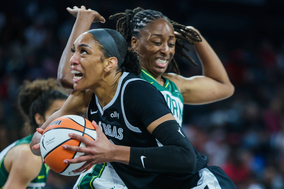 Aces center A'ja Wilson (22) drives the ball past Seattle Storm forward Nneka Ogwumike (3) duri ...