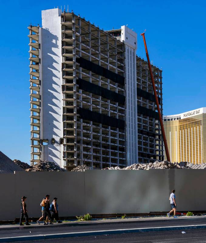 People walk past the temporary wall as preparations for the upcoming implosion continue at the ...