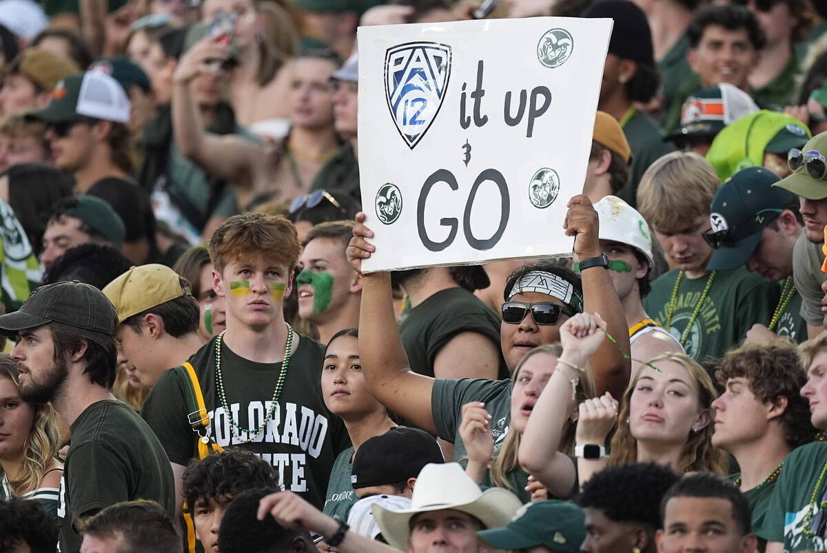 Fan holds up placard to note Colorado State move to the Pac-12 Conference in the first half of ...