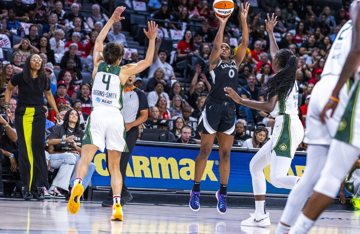 Aces guard Jackie Young (0) gets off a three-point basket over Seattle Storm center Ezi Magbego ...