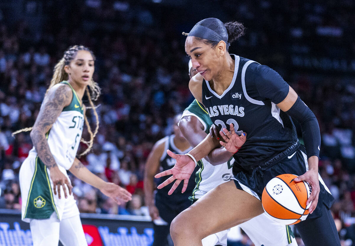 Aces center A'ja Wilson (22) is fouled on the drive by Seattle Storm guard Jordan Horston (23) ...