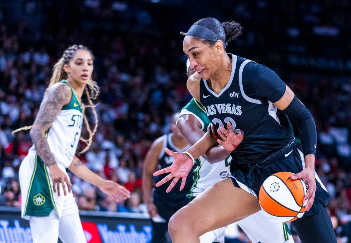 Aces center A'ja Wilson (22) is fouled on the drive by Seattle Storm guard Jordan Horston (23) ...