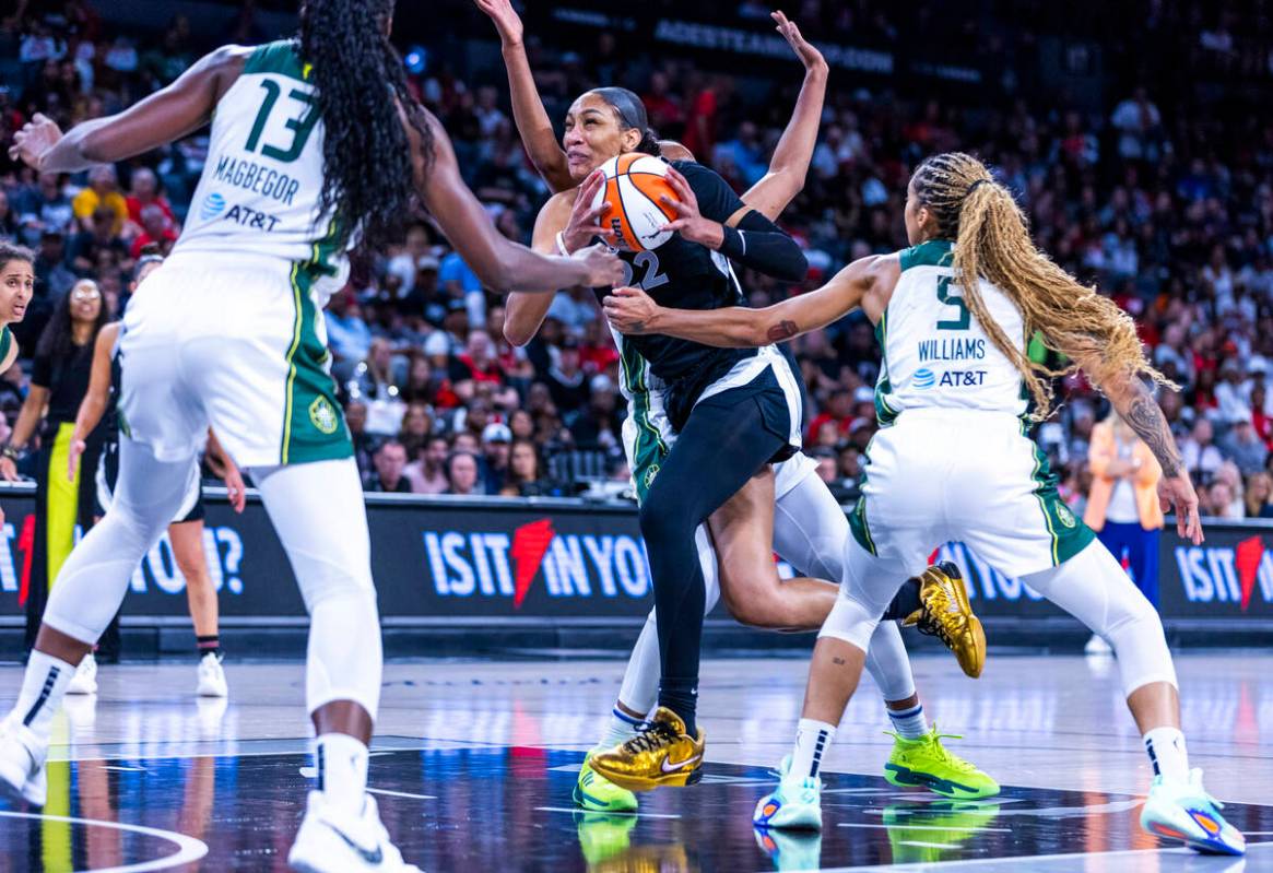 Aces center A'ja Wilson (22) drives to the net against Seattle Storm forward Gabby Williams (5) ...