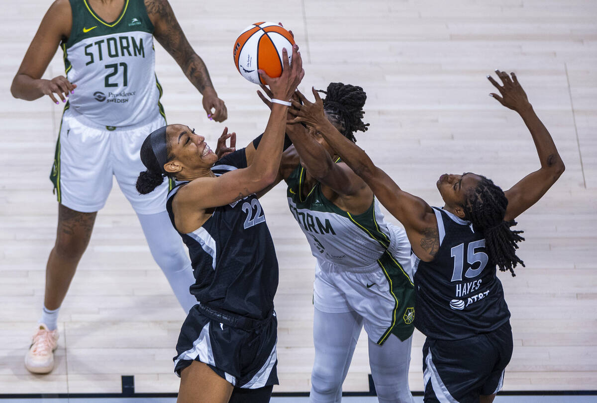 Aces center A'ja Wilson (22) pulls down a rebound over Seattle Storm forward Nneka Ogwumike (3) ...