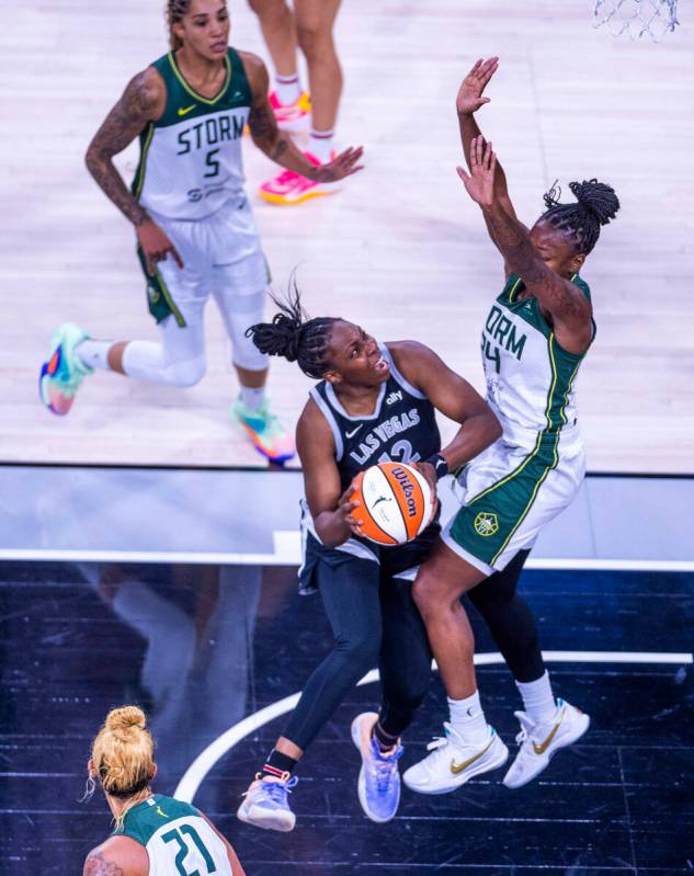 Aces guard Chelsea Gray (12) takes on Seattle Storm guard Jewell Loyd (24) under the basket for ...