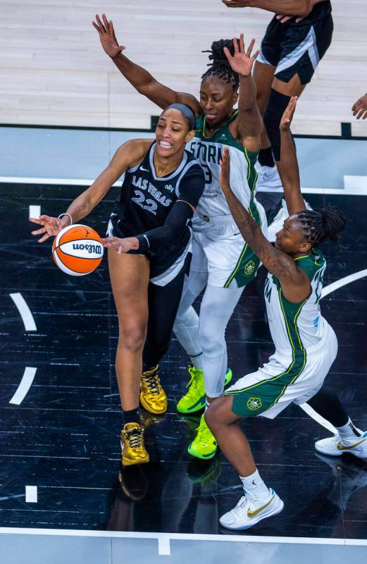 Aces center A'ja Wilson (22) gets off a pass under tight defense by Seattle Storm center Ezi Ma ...