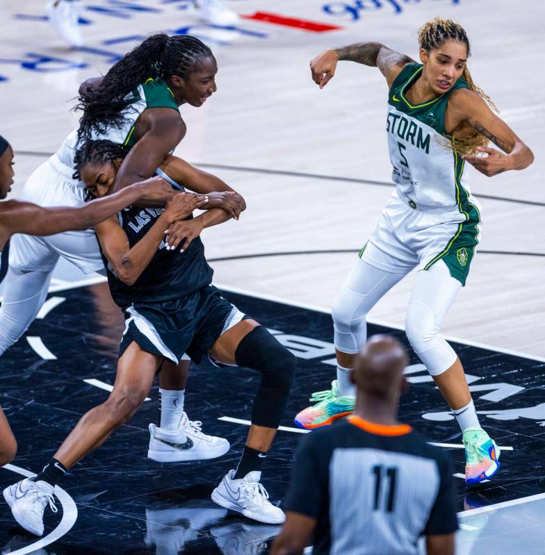 Aces guard Tiffany Hayes (15) is mugged while chasing a rebound by Seattle Storm center Ezi Mag ...