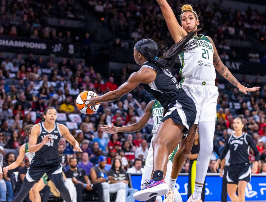 Aces guard Jackie Young (0) curls around Seattle Storm center Mercedes Russell (21) for a pass ...