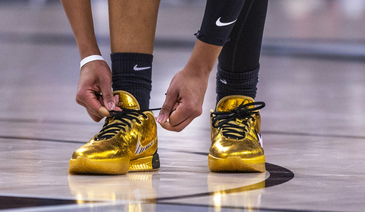 Aces center A'ja Wilson (22) reties her laces against the Seattle Storm during the first half o ...