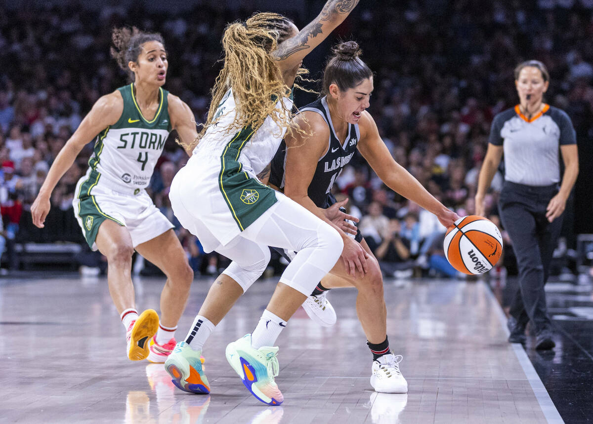 Aces guard Kelsey Plum (10) looks to fight off a double team by Seattle Storm forward Gabby Wil ...