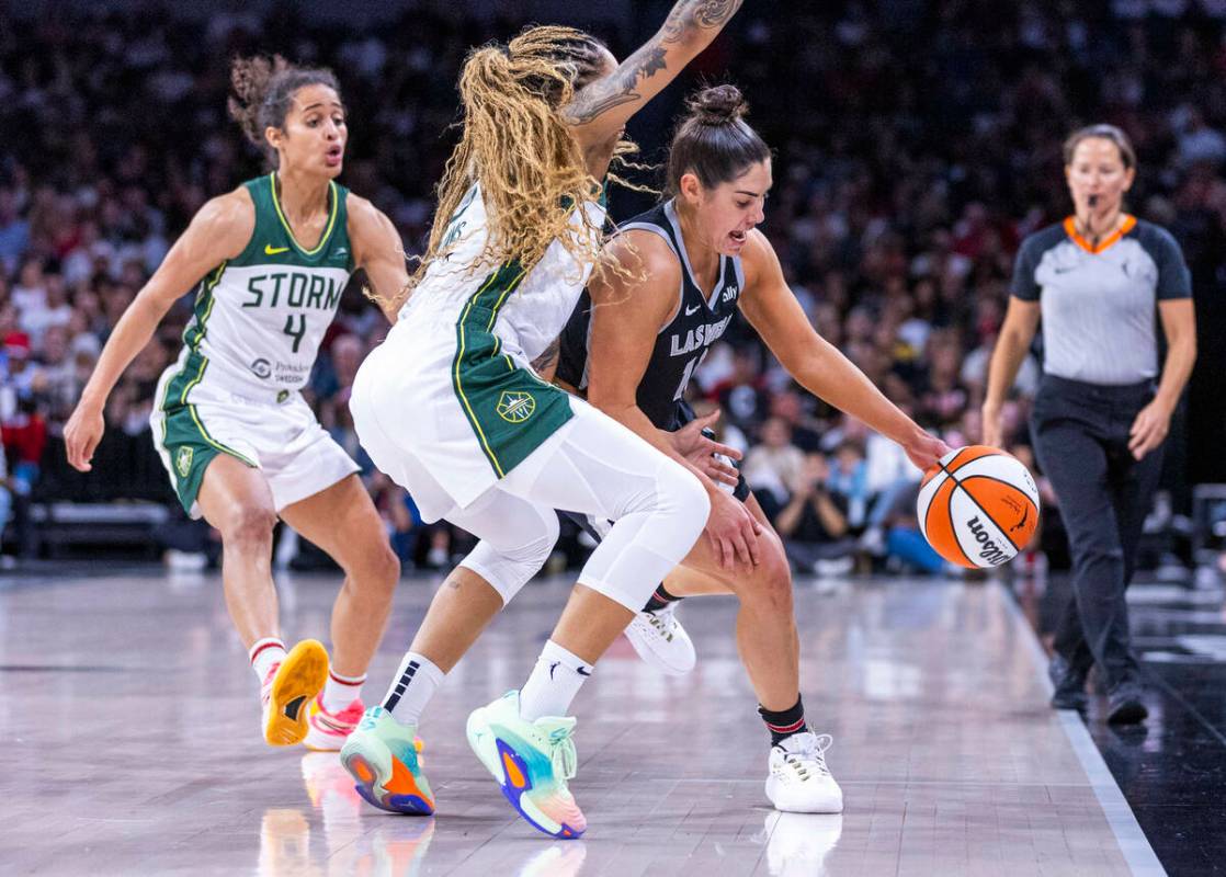 Aces guard Kelsey Plum (10) looks to fight off a double team by Seattle Storm forward Gabby Wil ...