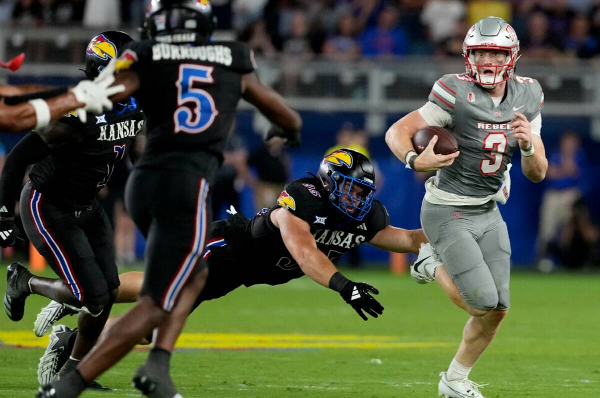 UNLV quarterback Matthew Sluka (3) gets past Kansas defensive end Dylan Wudke (95) as he runs i ...