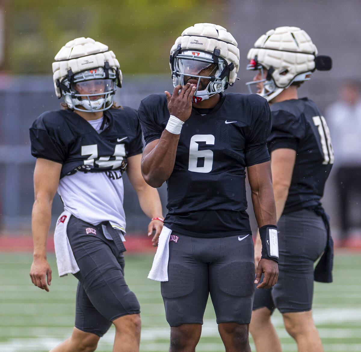 UNLV quarterback Hajj-Malik Williams (6), center, licks his hand flanked by quarterbacks Gael O ...