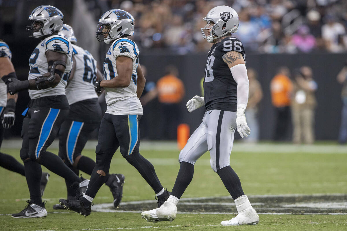 Raiders defensive end Maxx Crosby (98) walks on the field with his right ankle in a boot during ...