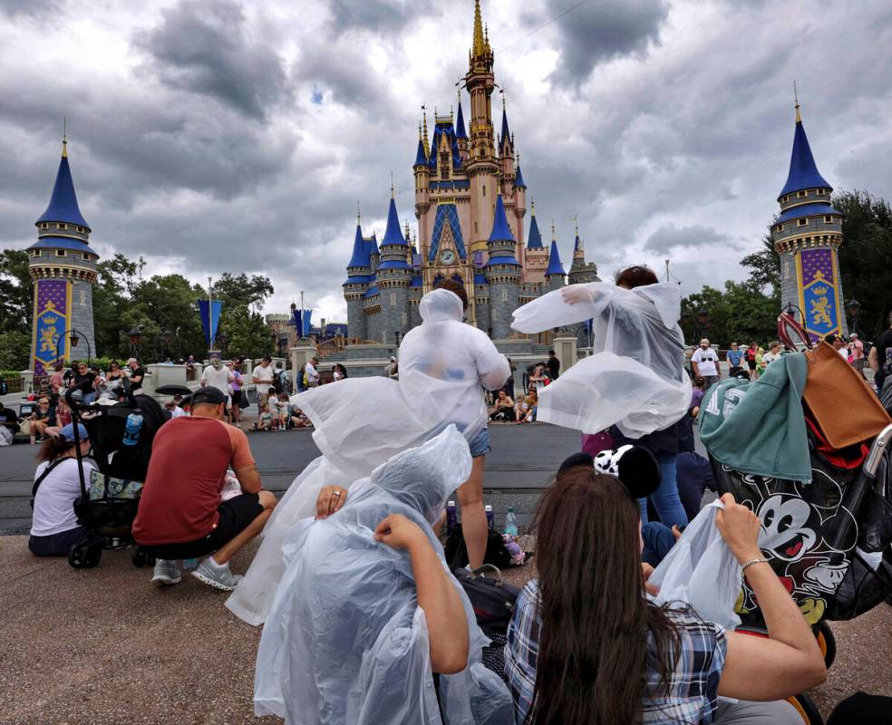 Guests at the Magic Kingdom break out ponchos at Cinderella Castle as bands of weather from Hur ...