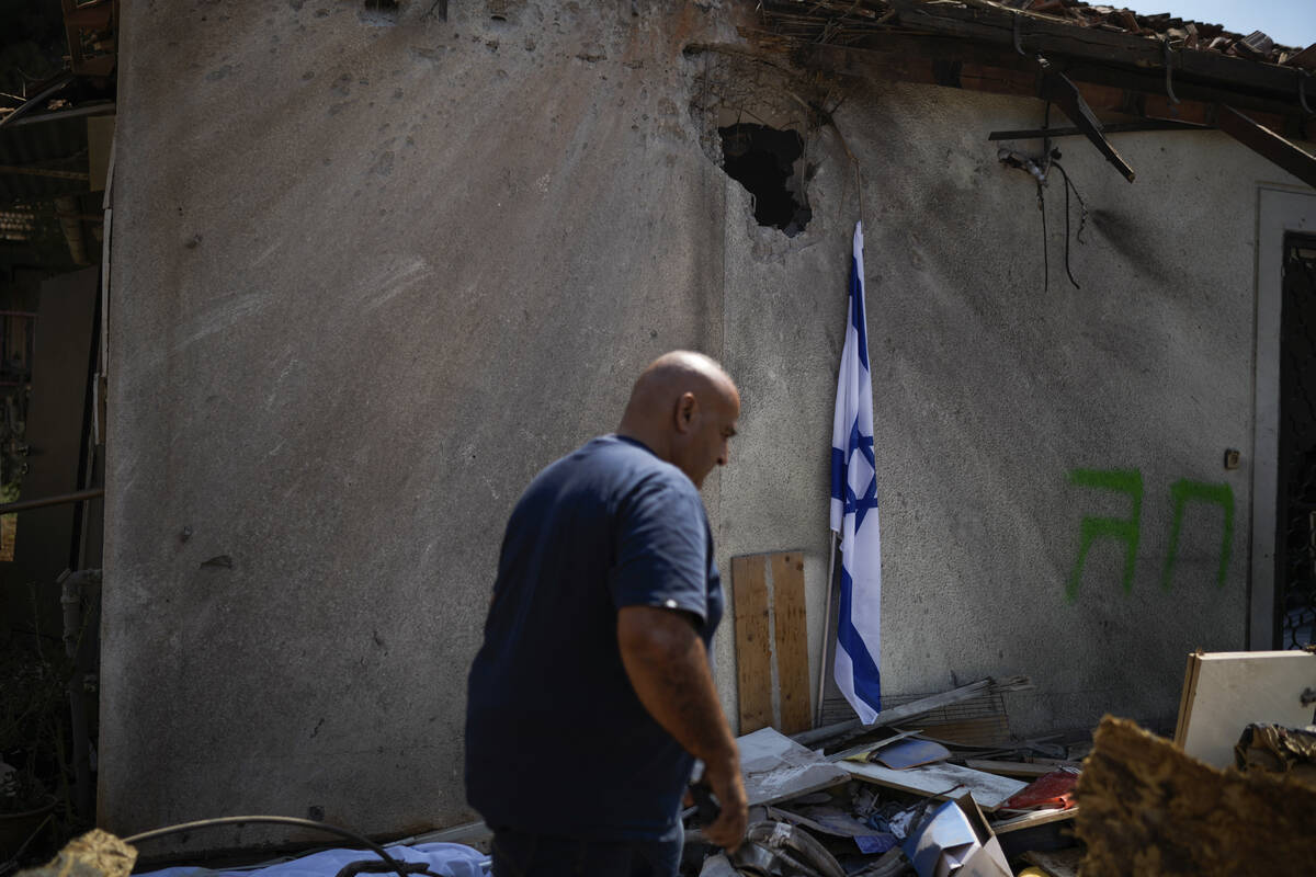 A man looks at a damaged house that was hit by a rocket fired from Lebanon, near Safed, norther ...