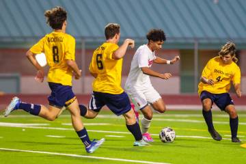 Liberty soccer forward Justin Gilliland (6) kicks the ball away from a group of South Ridge pla ...