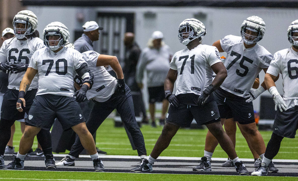 Raiders guard Jackson Powers-Johnson (70) and offensive tackle DJ Glaze (71) join teammates in ...