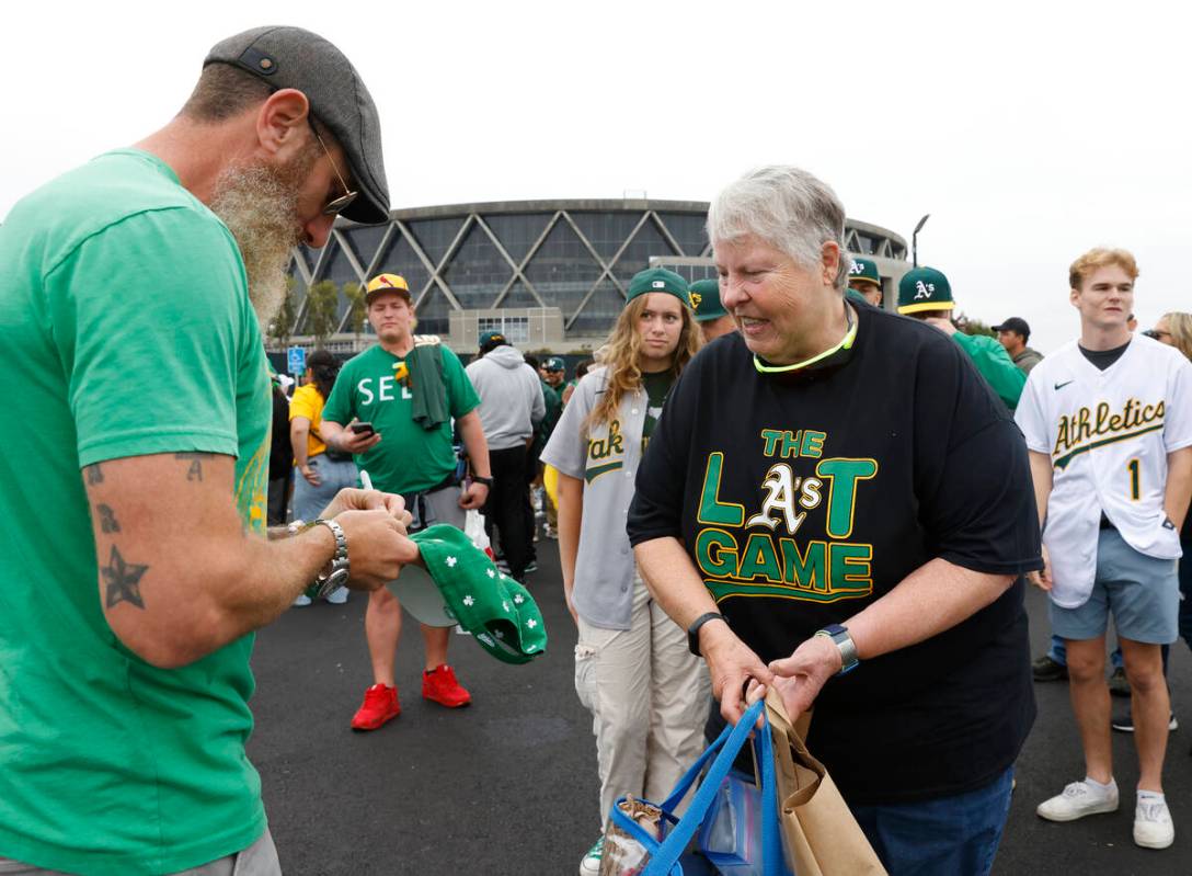 Former Oakland Athletics pitcher Dallas Braden signs an autograph for Charlotte Scannell outsid ...