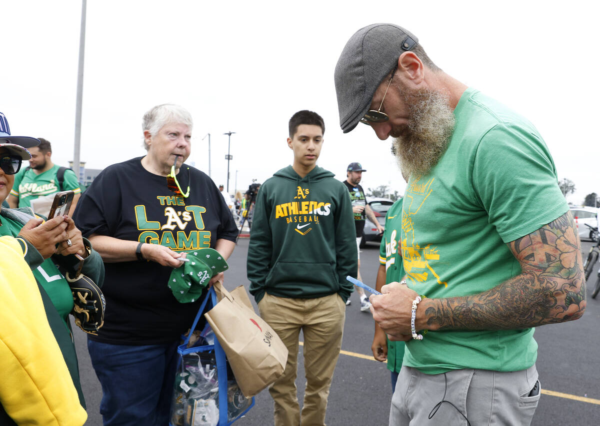 Former Oakland Athletics pitcher Dallas Braden signs autographs for fans outside Oakland Colise ...