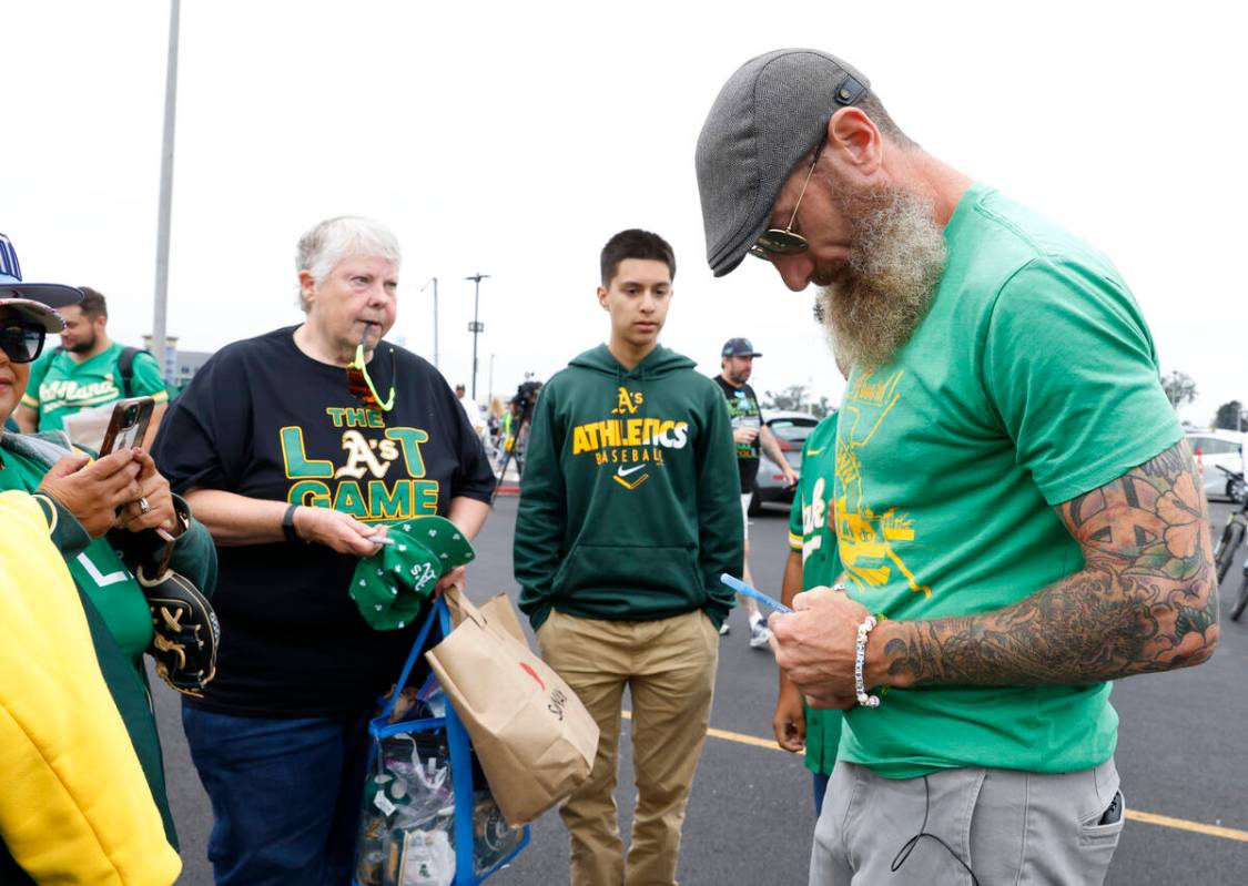 Former Oakland Athletics pitcher Dallas Braden signs autographs for fans outside Oakland Colise ...