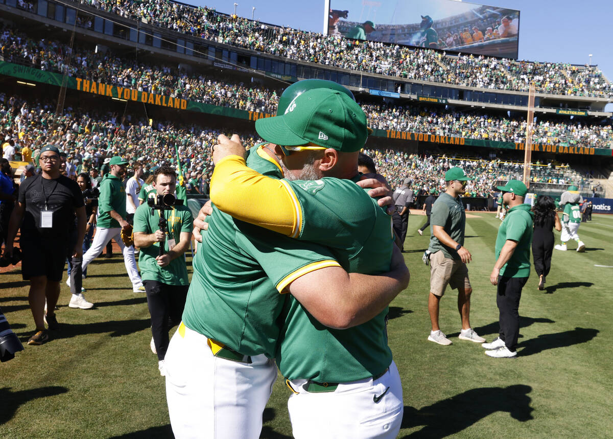 Oakland Athletics manager Mark Kotsay, right, and first base coach Bobby Crosby hug each other ...