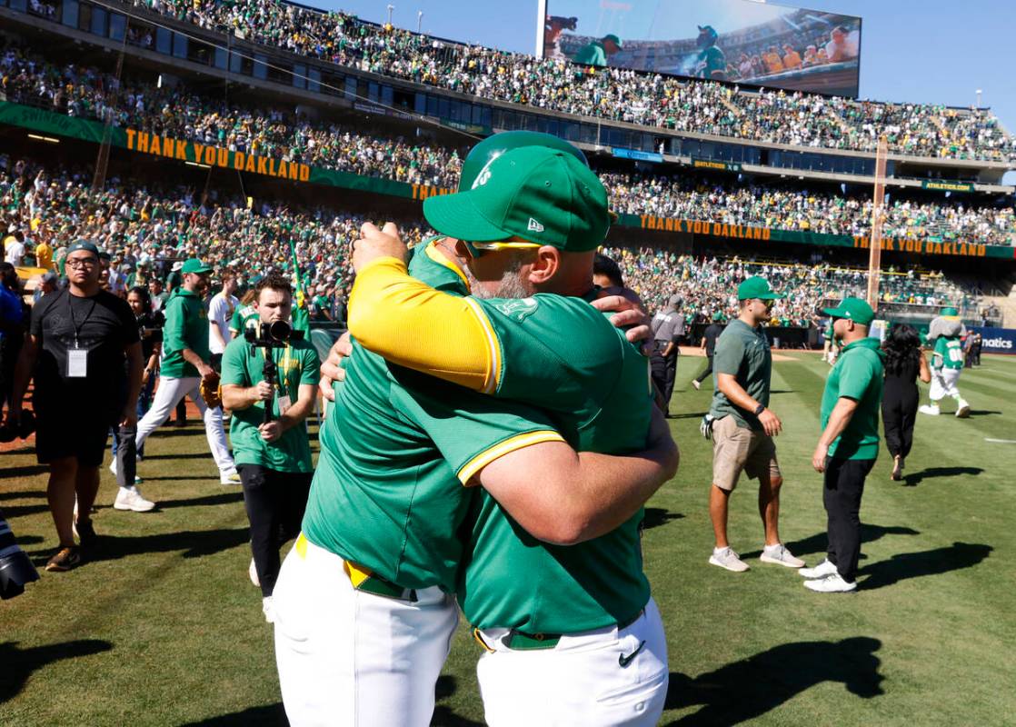 Oakland Athletics manager Mark Kotsay, right, and first base coach Bobby Crosby hug each other ...