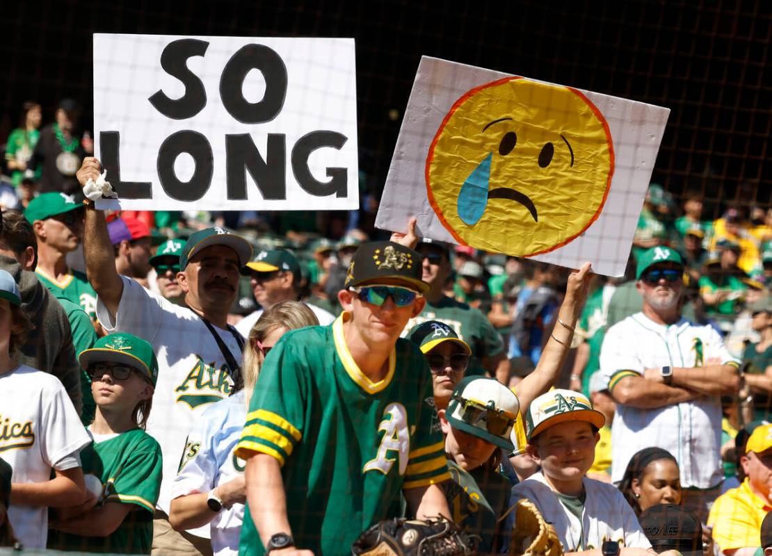 Oakland Athletics fans hold signs during the final home game against the Texas Rangers at Oakla ...