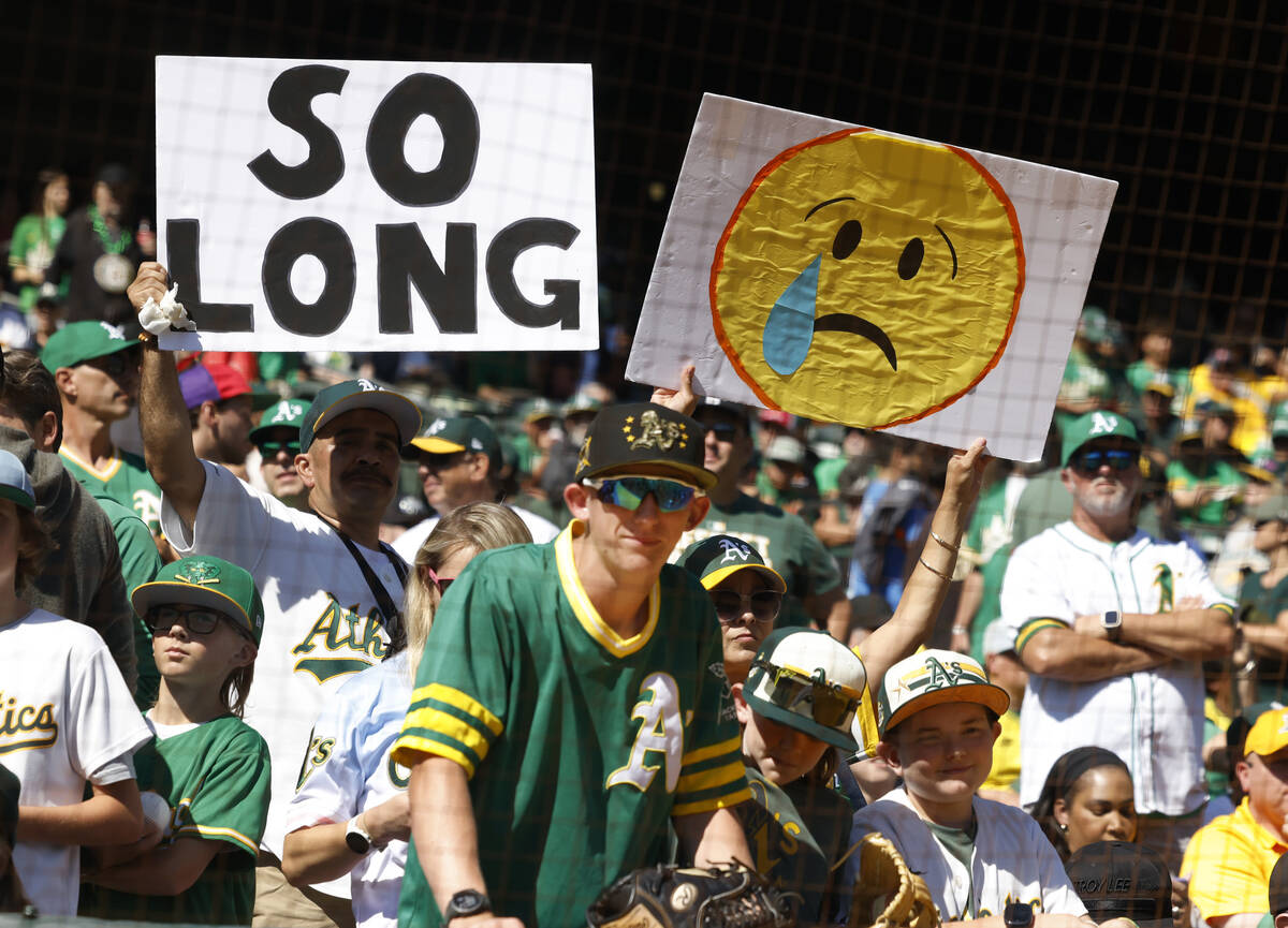 Oakland Athletics fans hold signs during the final home game against the Texas Rangers at Oakla ...