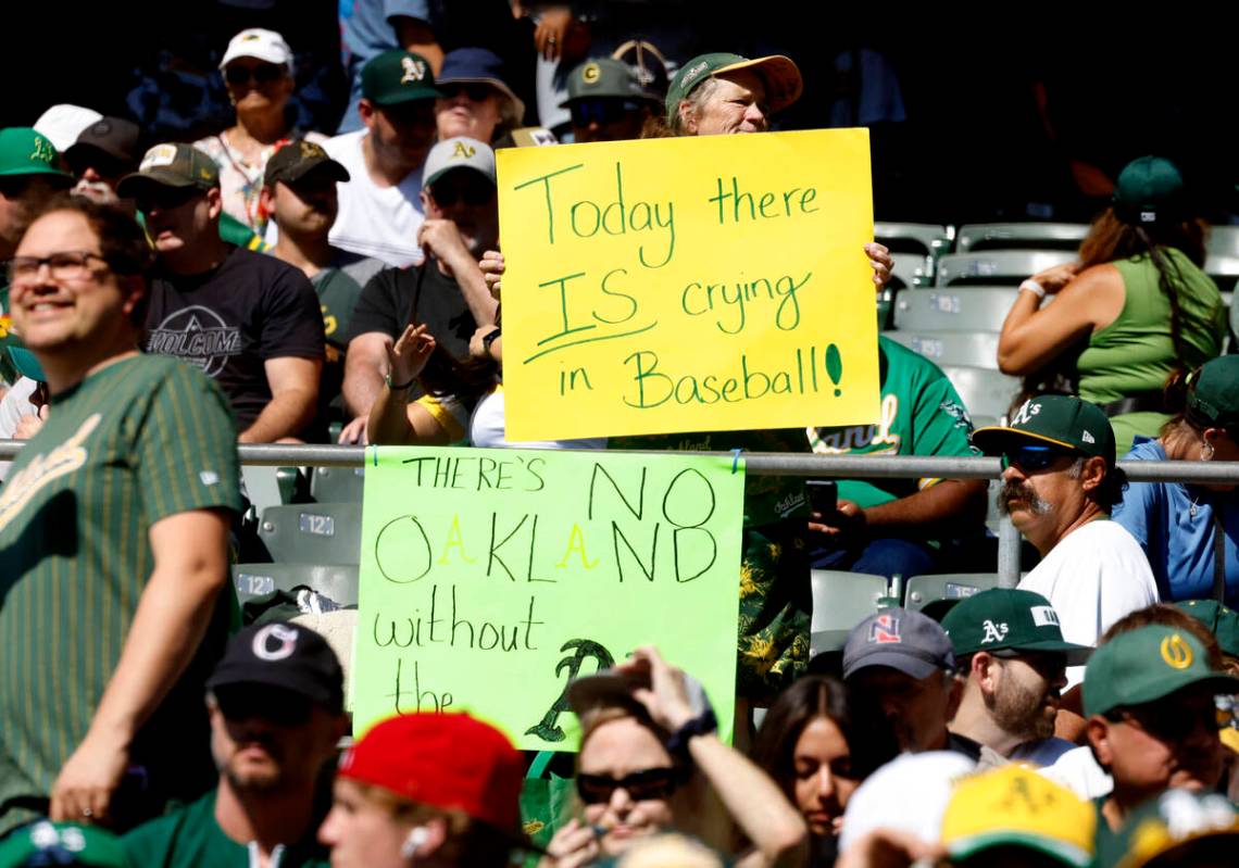 Oakland Athletics fans hold signs during the final home game against the Texas Rangers at Oakla ...