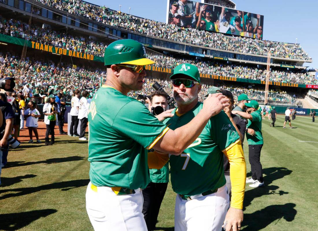 Oakland Athletics manager Mark Kotsay, right, and first base coach Bobby Crosby comfort each o ...