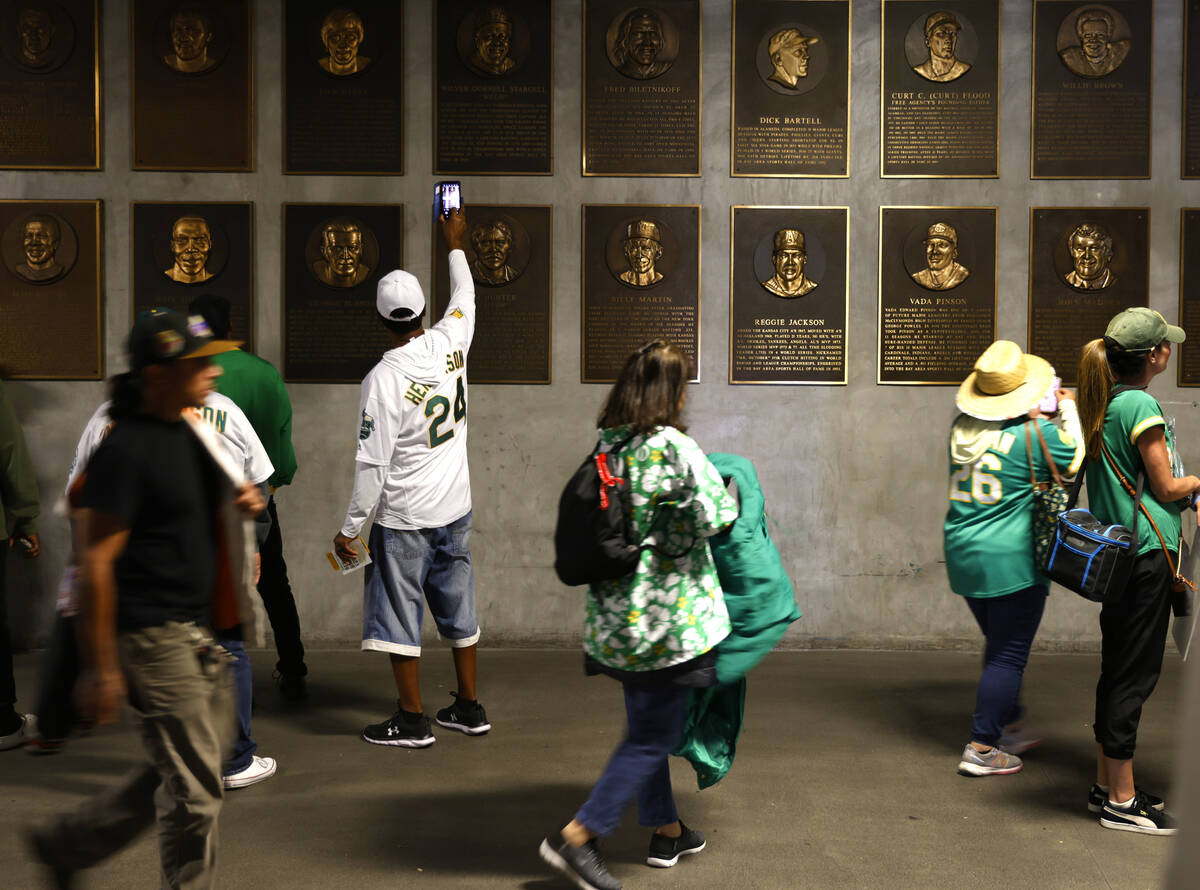 Fans take pictures of former Oakland Athletics players plaques along the second level concourse ...