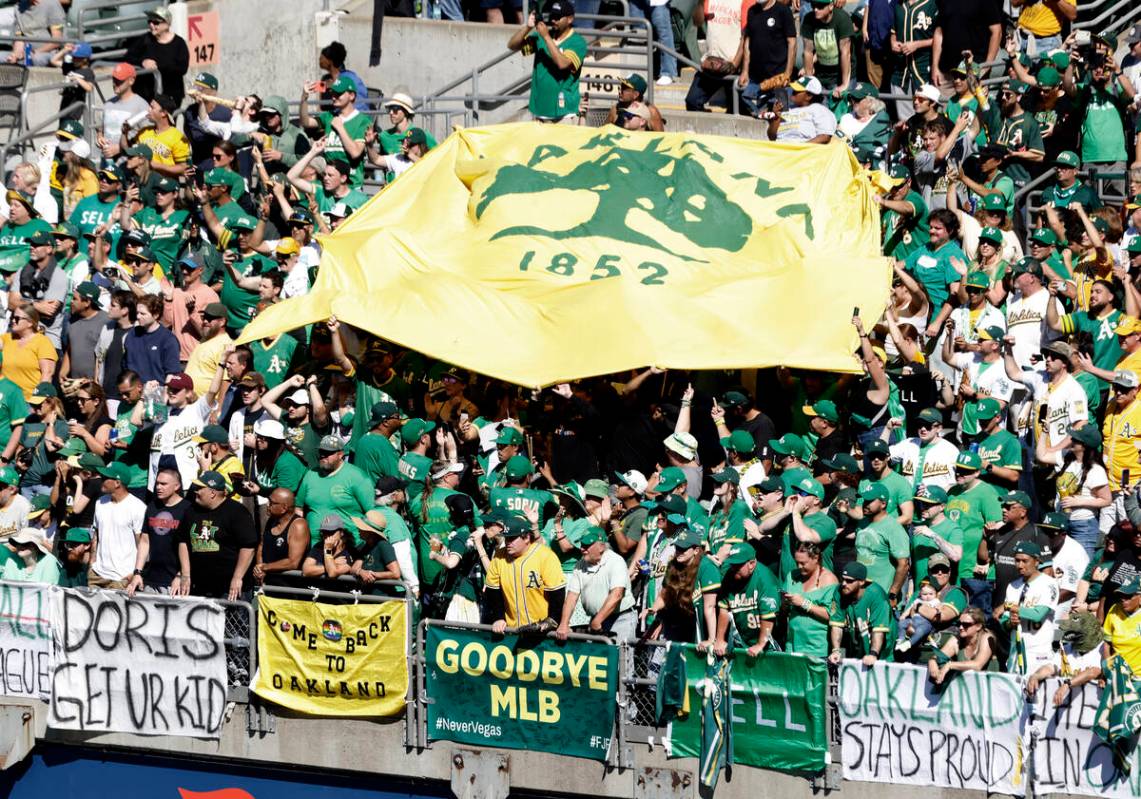 Oakland Athletics fans post signs and wave a flag as they watch the final home game against the ...