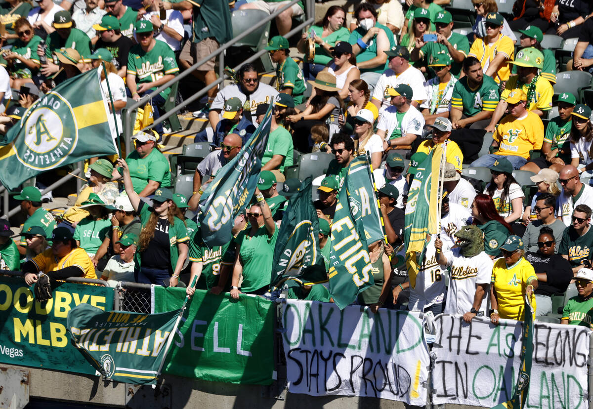 Oakland Athletics fans post signs and wave flags as they watch the final home game against the ...