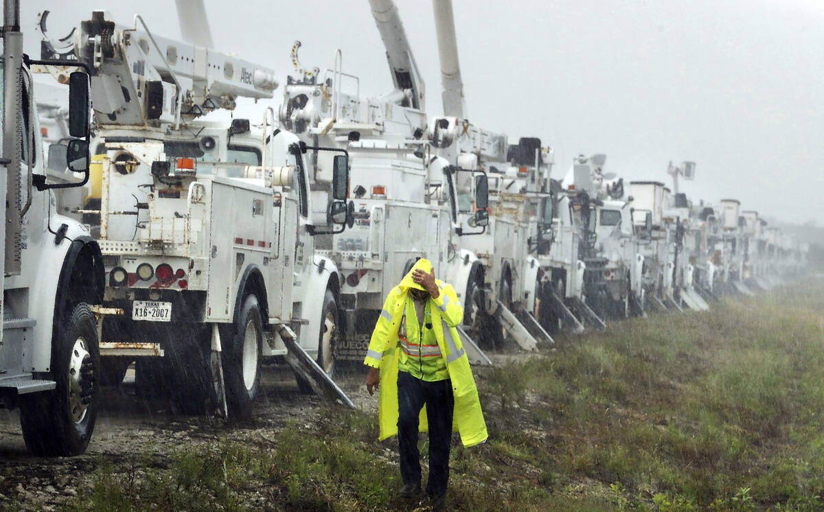 Charles Starling, a lineman with Team Fishel, is pelted with rain as he walks by a row of elect ...