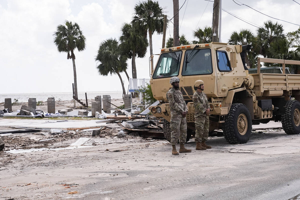 Members of the Florida National Guard stand at their post near destruction in the aftermath of ...