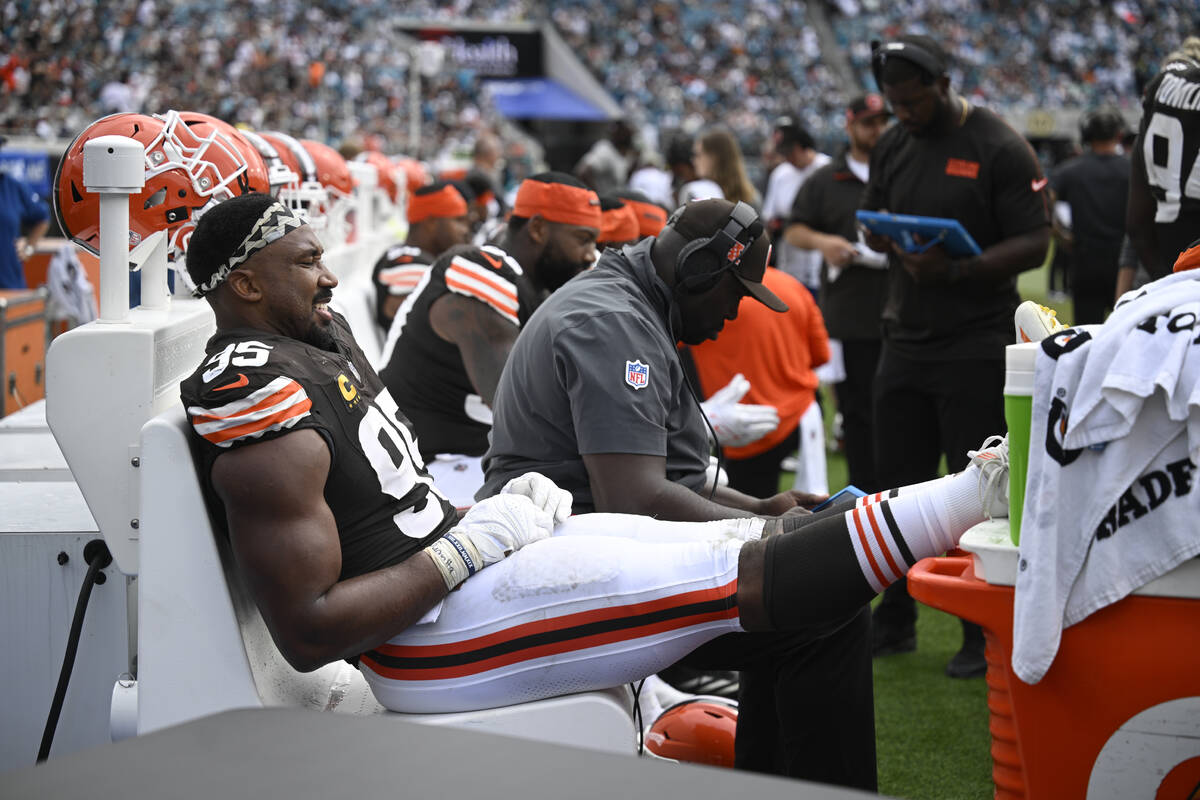 Cleveland Browns defensive end Myles Garrett (95) rests his feet while sitting on the bench dur ...