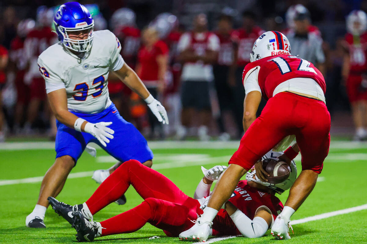 Liberty quarterback Elijah Espinoza (12) retrieves the ball after losing it during a high schoo ...