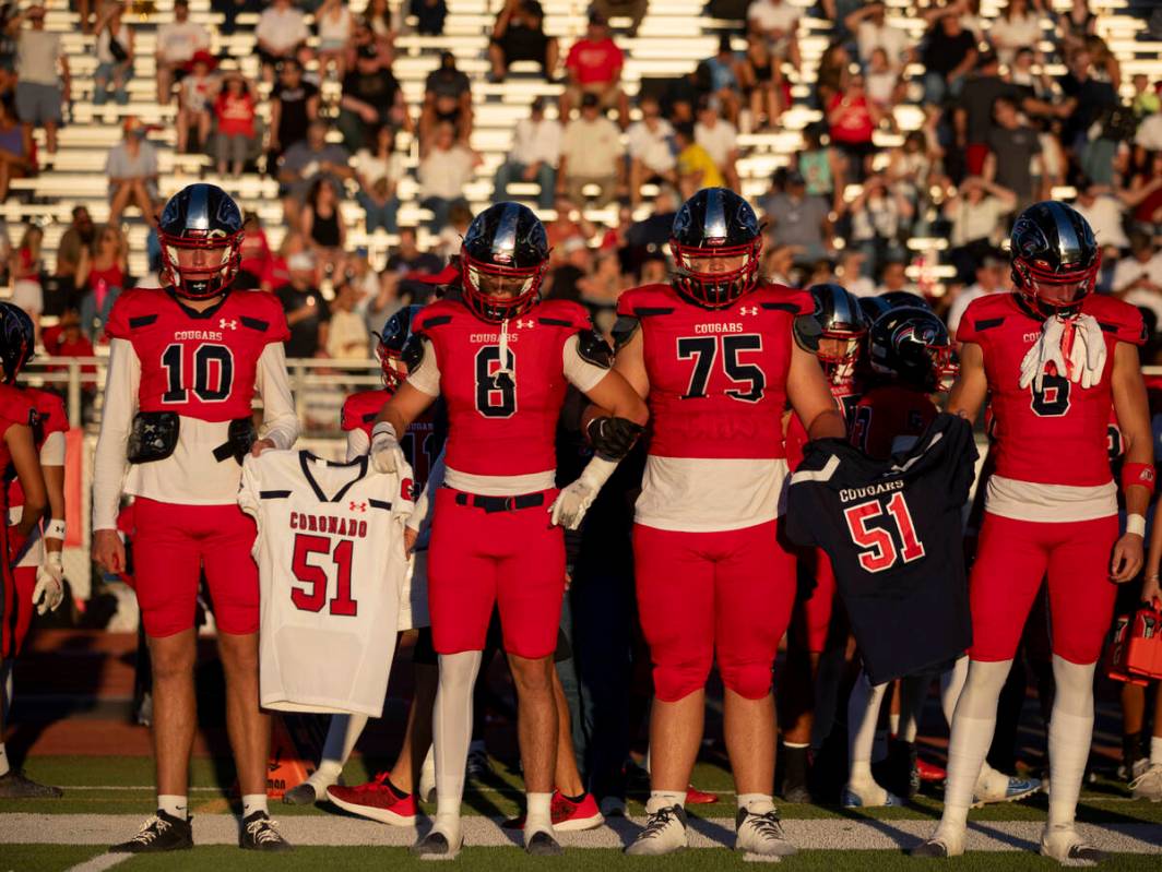 Coronado captains hold the jersey of Coronado senior David Merabyan before the high school foot ...