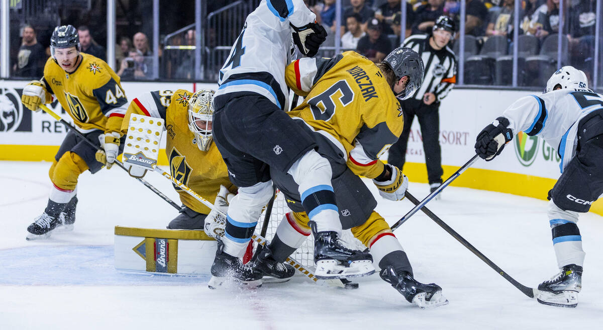 Golden Knights defenseman Kaedan Korczak (6) keeps the puck from Utah Hockey Club forward Cole ...