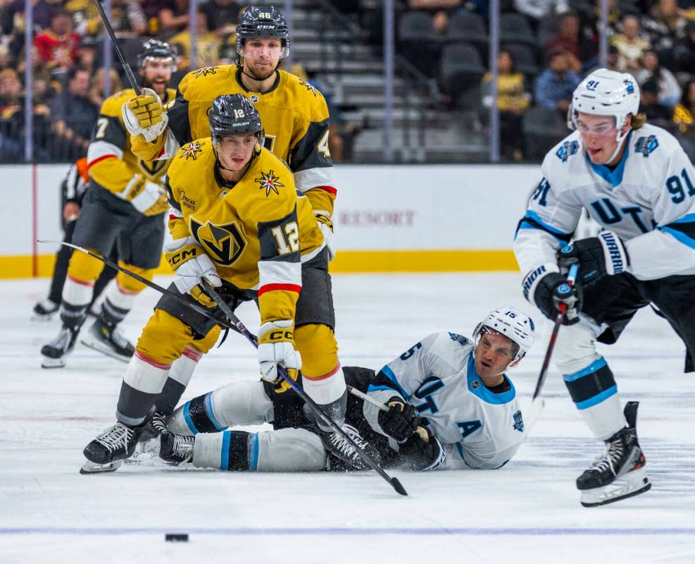 Golden Knights center Jakub Brabenec (12) eyes the puck as Utah Hockey Club forward Alex Kerfoo ...