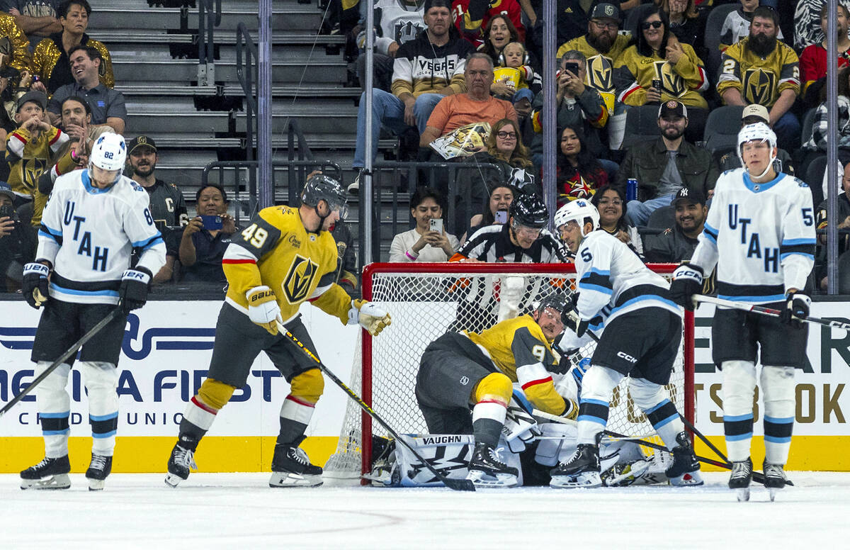 Golden Knights center Jack Eichel (9) is checked into the goal atop of Utah Hockey Club goalten ...