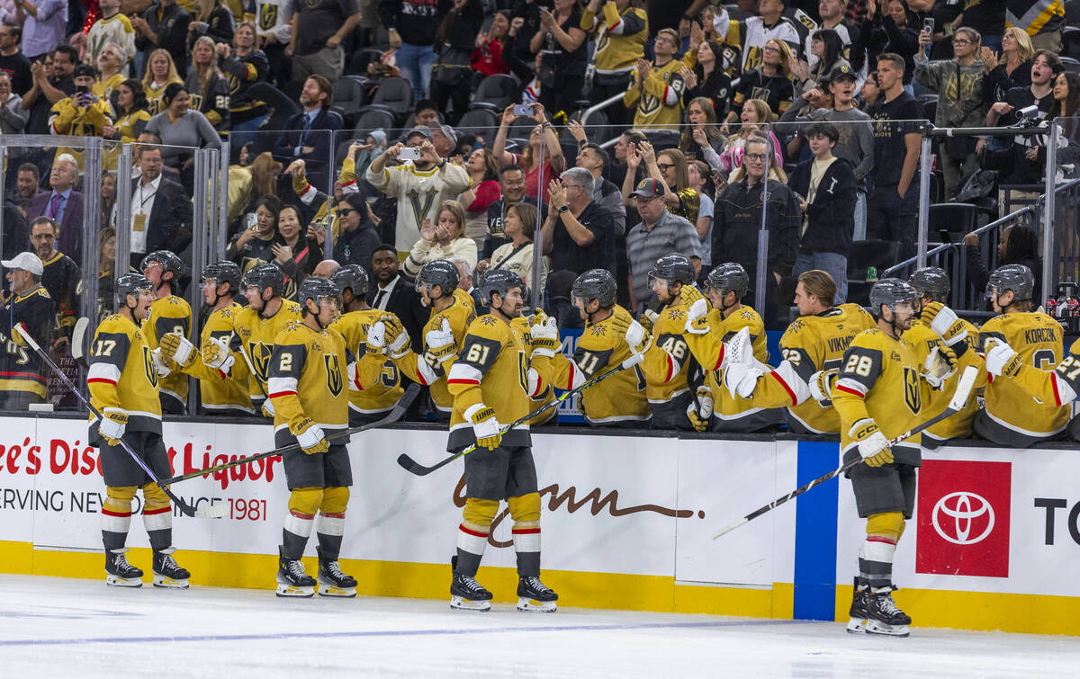 Golden Knights players celebrate a goal against Utah Hockey Club goaltender Jaxson Stauber (33) ...