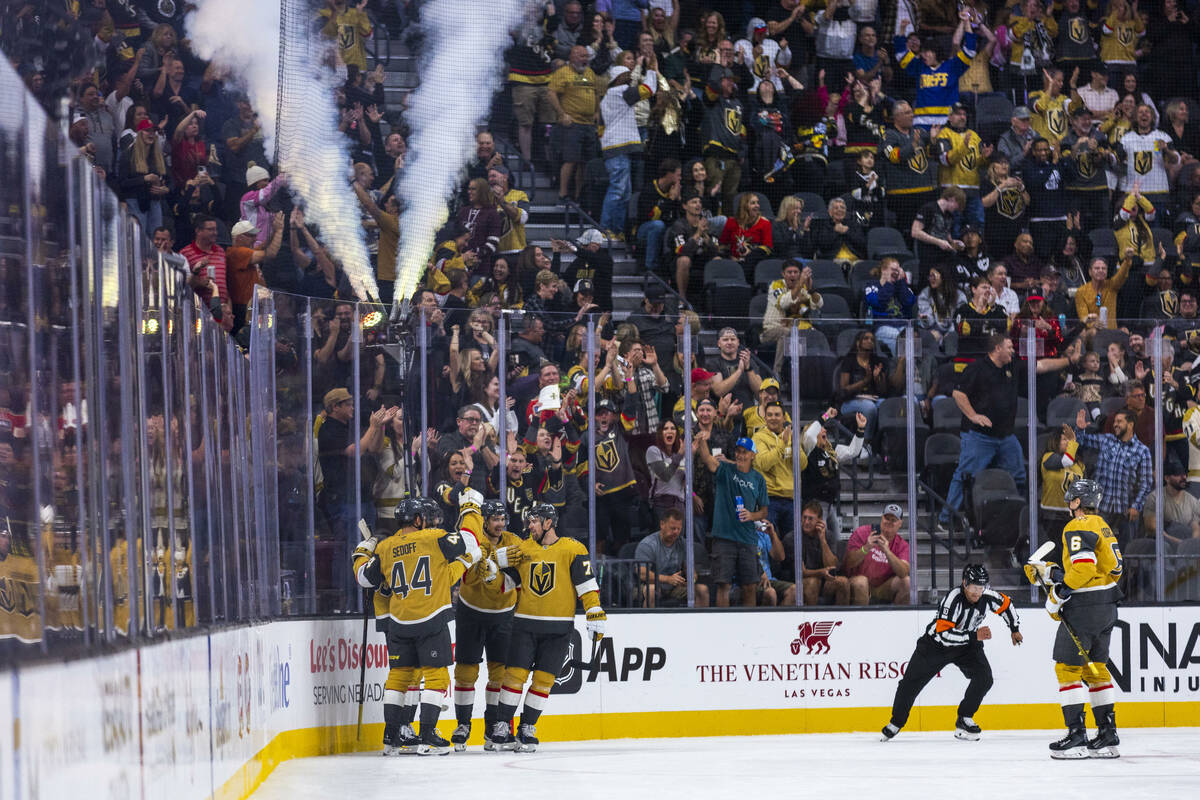 Golden Knights players celebrate a goal against Utah Hockey Club goaltender Jaxson Stauber (33) ...