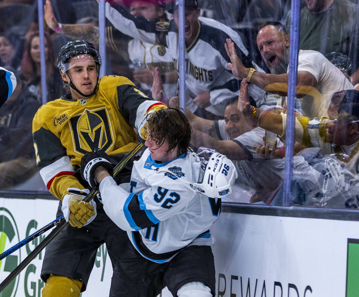 Golden Knights defenseman Zach Whitecloud (2) punches Utah Hockey Club forward Logan Cooley (92 ...