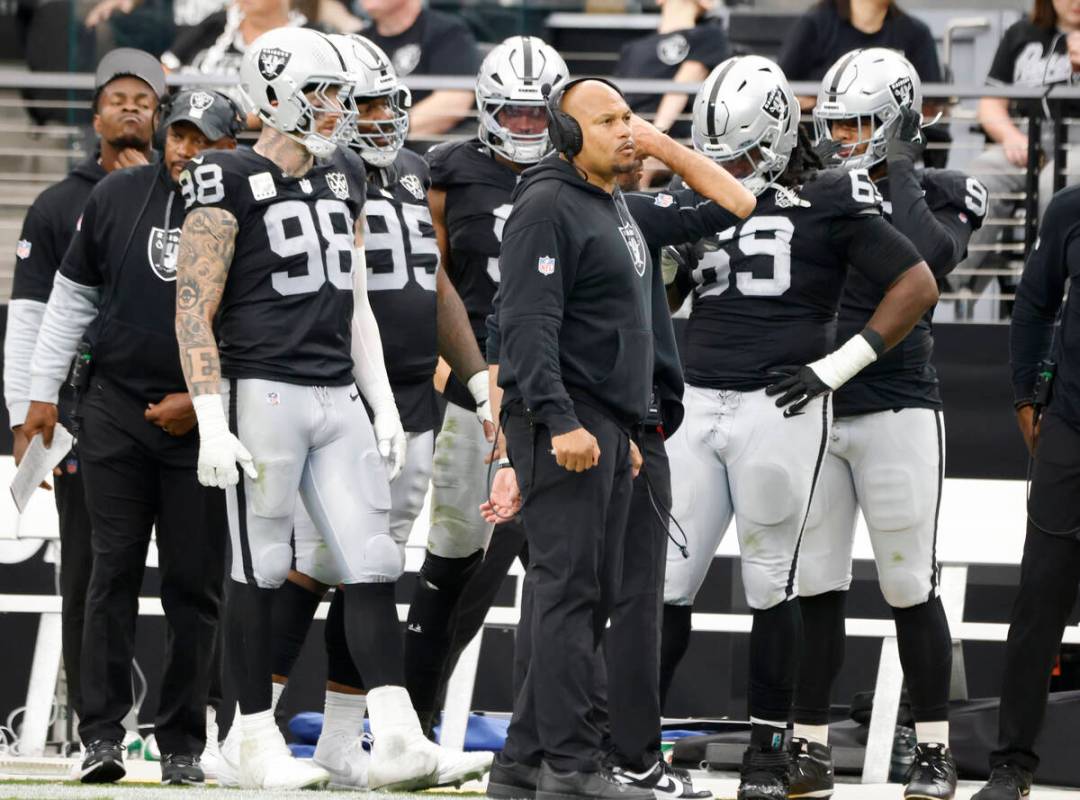 Raiders head coach Antonio Pierce, center, defensive end Maxx Crosby (98), defensive tackle Joh ...