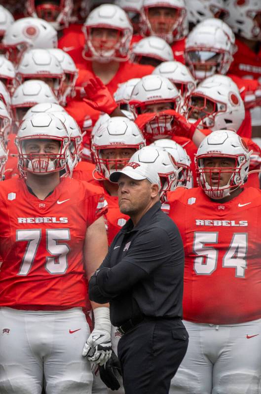 UNLV head coach Barry Odom and the rest of the team wait to take the field before the college f ...