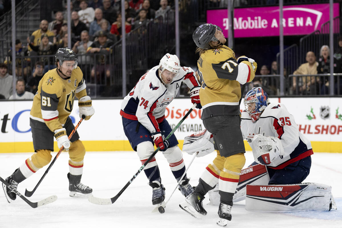 Golden Knights center William Karlsson (71) struggles at the net with Capitals goaltender Darcy ...